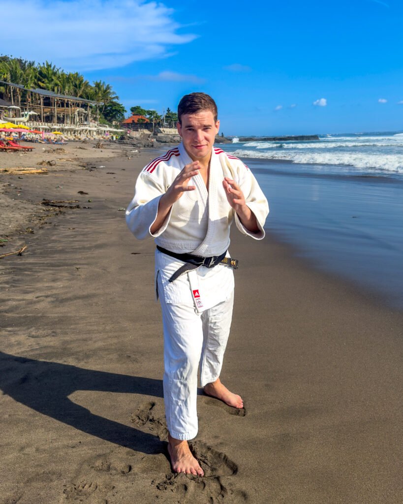 Julien Brulard in a white judogi on a beach