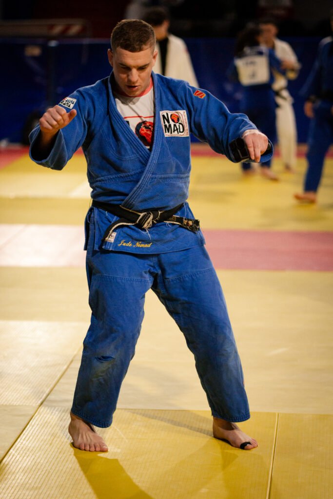 Julien Brulard coaching on the mat in a blue judogi
